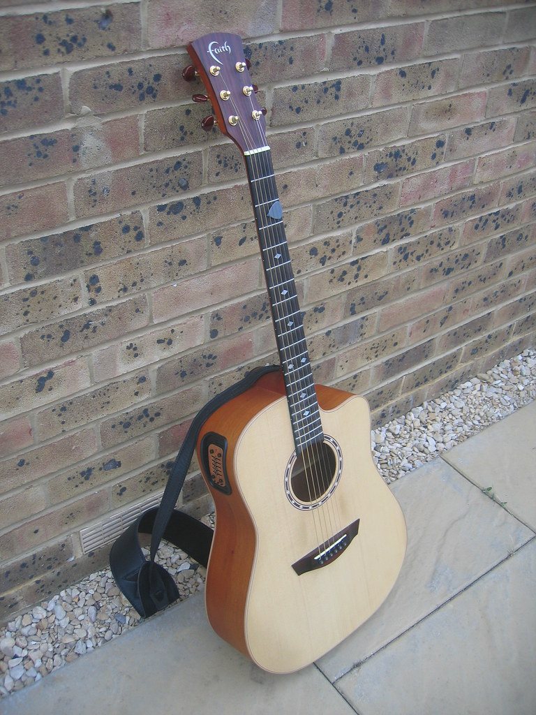 Electro-acoustic guitar on a wooden table Electro-acoustic guitar on a wooden table