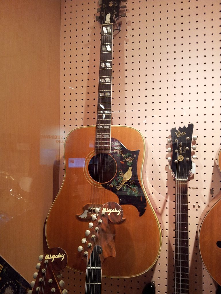 Acoustic guitar image acoustic guitars exposées derrière a vitrine, on panneau perforé rose