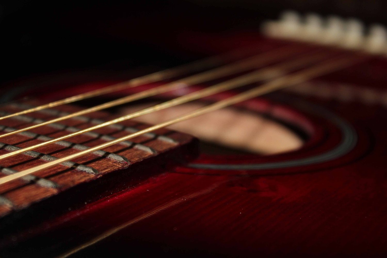 Acoustic guitar image close-up of strings métalliques enroulées on a instrument dark